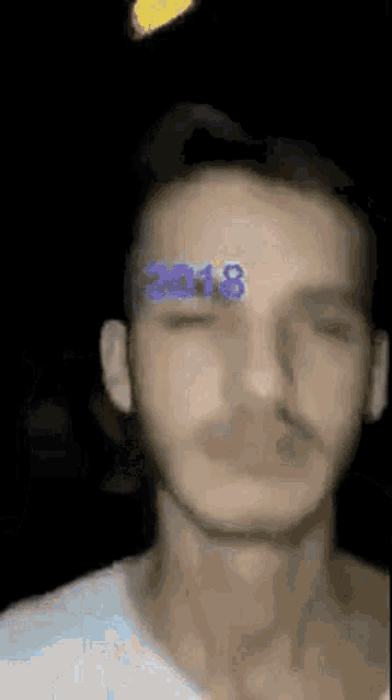 a close up of a man 's face with a sticker on his forehead that says 2018 .