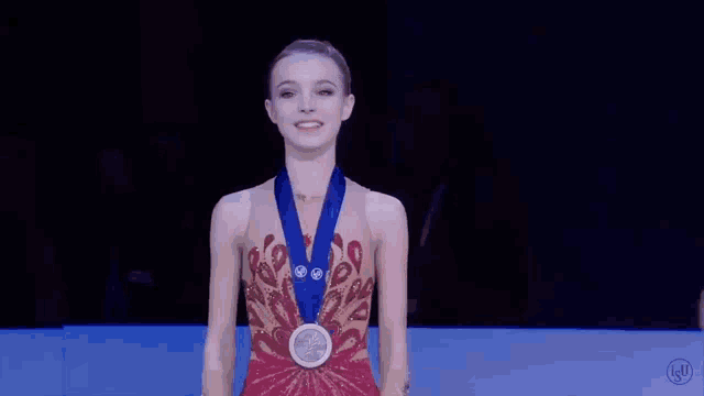 a woman is wearing a medal around her neck and smiling .
