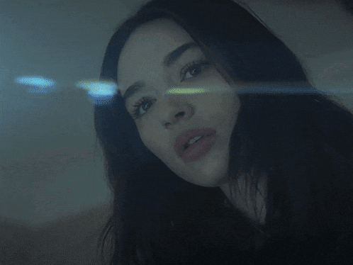 a woman with long dark hair looks at the camera
