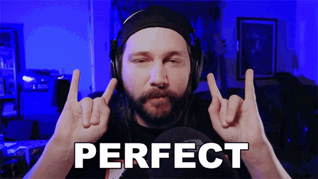 a man wearing headphones making a horns sign in front of a perfect sign