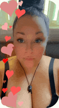 a woman wearing a black bra and a necklace with hearts around her
