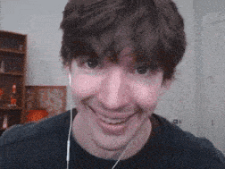 a man wearing ear buds is smiling for the camera