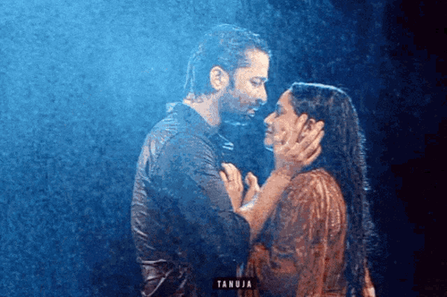 a man and a woman are kissing in the rain and the word tanuja is on the bottom