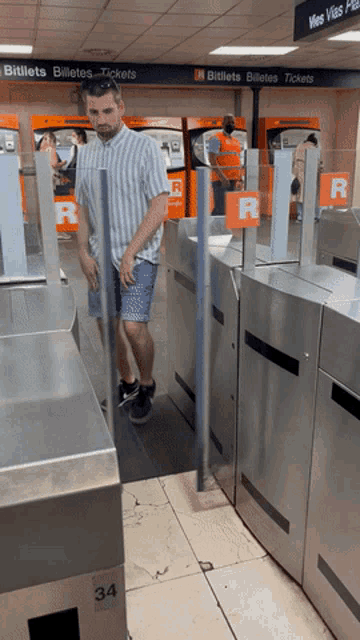 a man walking through a gate with a sign that says bitllets billetes tickets
