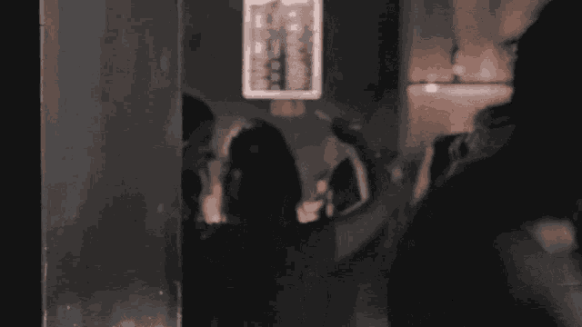 a group of people are standing in a dark room with a sign that says ' a ' on it