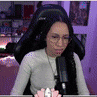 a woman wearing glasses and headphones is sitting in front of a microphone in a chair .