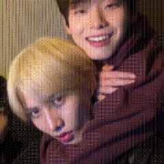 a man is giving another man a piggyback ride and they are smiling and looking at the camera .
