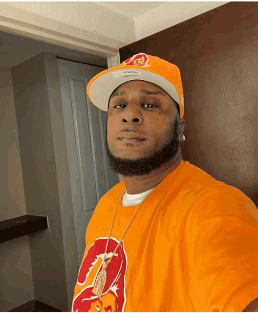 a man wearing an orange t-shirt with the number 2 on it