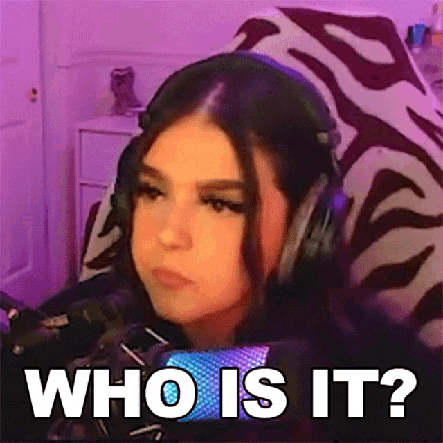 a girl wearing headphones is sitting in front of a microphone and asking who is it ?