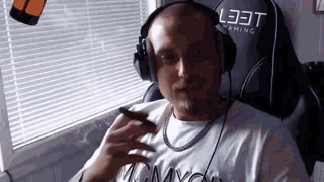 a man wearing headphones is smoking a cigar .