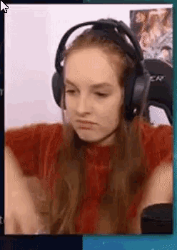 a woman wearing headphones is making a funny face while playing a video game .