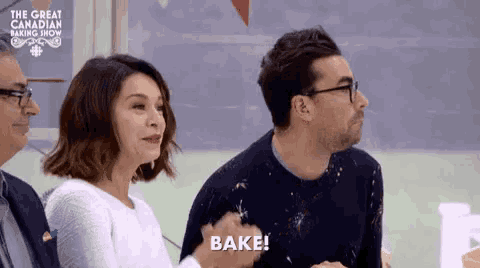 a group of people are sitting at a table and one of them is saying bake