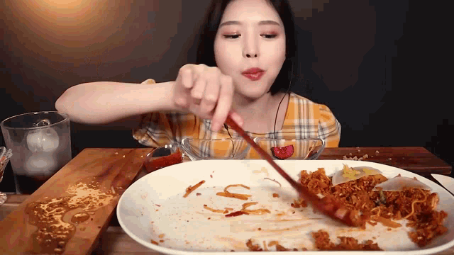 a woman eating a plate of food with a spoon