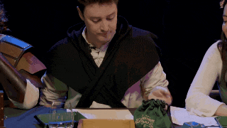 a man sitting at a table with a green bag that says ' wizard ' on the front