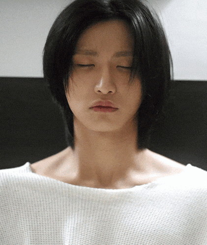 a man with his eyes closed and a white shirt on