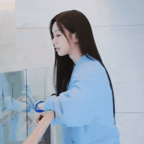 a woman in a blue robe is holding something in her hand .