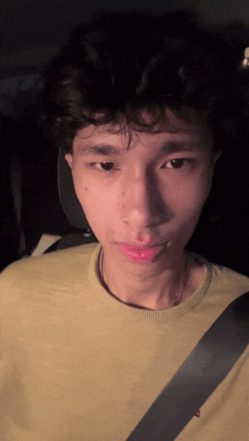 a young man wearing a yellow shirt with a black belt around his waist