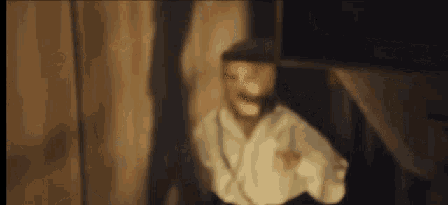 a blurry picture of a man wearing a hat and a white shirt