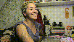 a woman is smiling while sitting at a table with books and cards