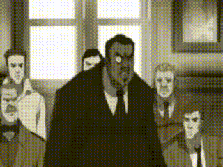a group of men in suits and ties are standing around a man in a suit and tie .