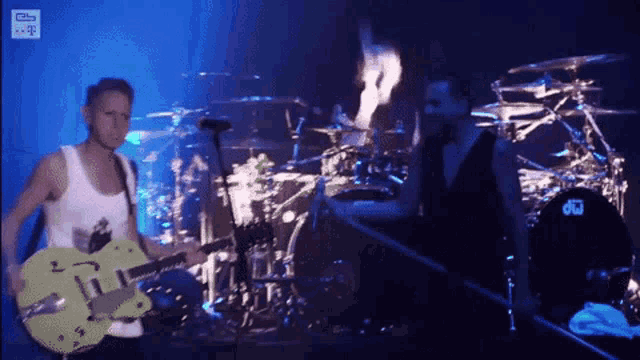 a man playing a guitar in front of a drum set that says drums
