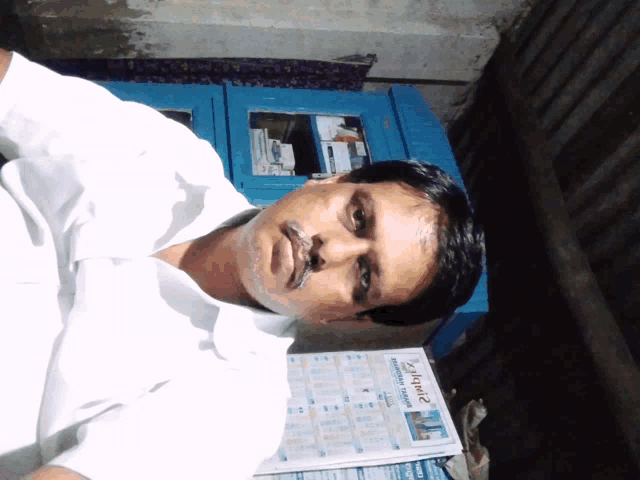 a man is sitting in front of a calendar that says ' aakash ' on it