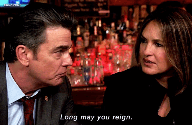 a man and a woman are talking in front of a bar and the woman says long may you reign