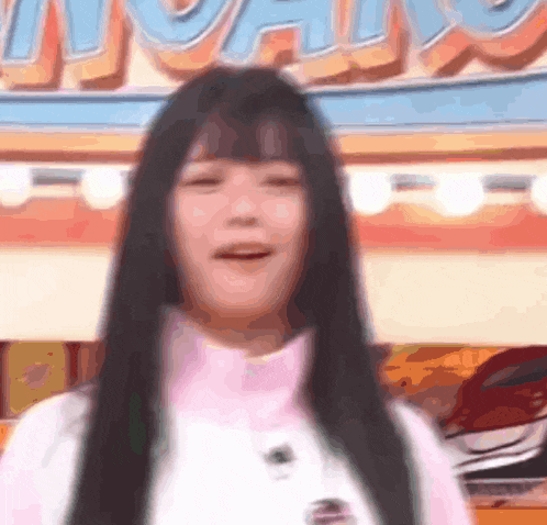 a woman with long black hair is standing in front of a carnival .