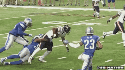 a football player with the number 23 on his jersey is being tackled