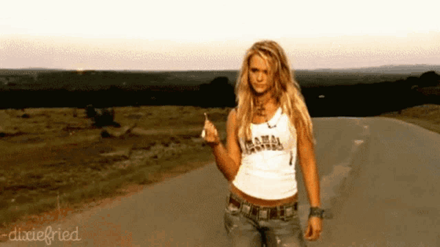 a woman is walking down a road wearing a dixie fried shirt