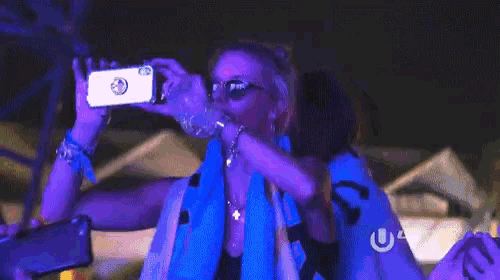a woman taking a picture of herself with a phone with the letters u and u on it