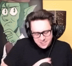a man wearing headphones and glasses is smiling in front of a cartoon character