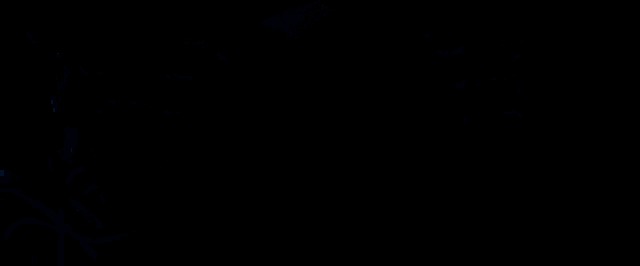 a man in a hooded robe looks at the camera in a dark room