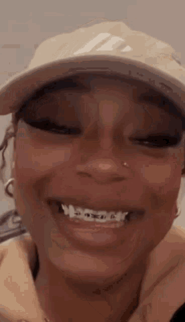 a close up of a woman wearing a hat and smiling .