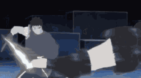 a man is kicking another man in the face with a sword in a dark room .