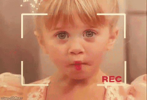 a little girl is making a funny face in front of a camera with the word rec in the corner .