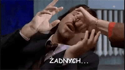a man in a suit and tie is being attacked by a woman 's hands .