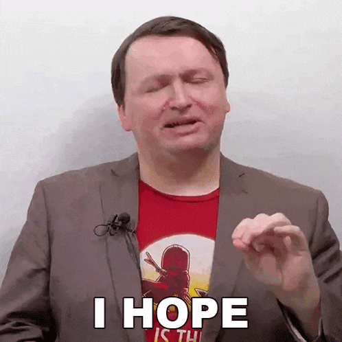 a man in a suit and red shirt is making a funny face and saying i hope .
