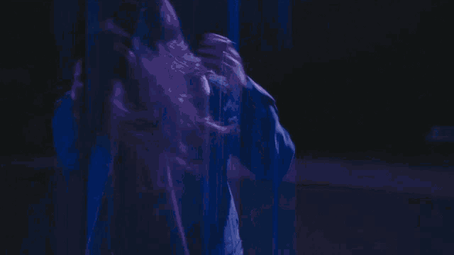 a woman with long hair is wearing a blue jacket with a hood