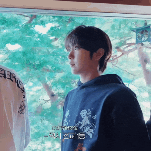 a man wearing a blue hoodie with chinese writing on it