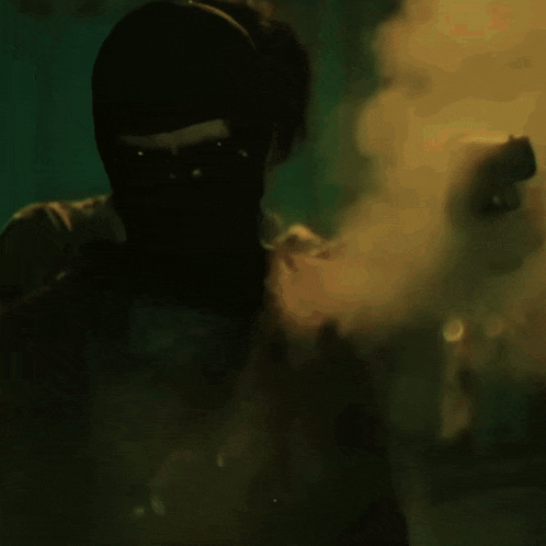 a silhouette of a man in a dark room with a yellow light behind him