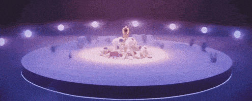 a group of people are standing in a circle on a stage surrounded by lights .