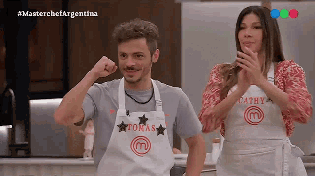 a man and a woman wearing aprons that say tomas and cathy on them