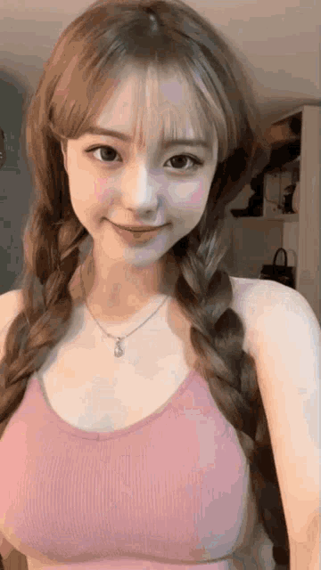 a girl with braids wearing a pink bra and a necklace