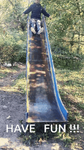 a man is sliding down a slide with the words have fun written below him