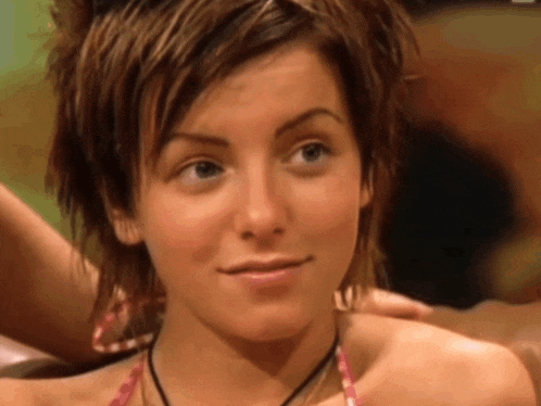 a close up of a woman 's face with short hair and a necklace around her neck