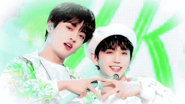 two young men are standing next to each other on a stage and one of them is wearing a beret .