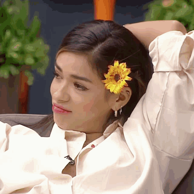 a woman with a flower in her hair has the letter t on her neck