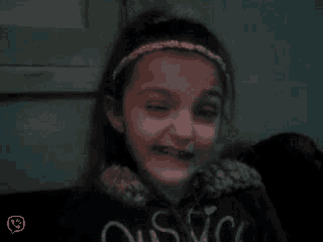 a little girl wearing a black shirt that says ' oasis ' on it