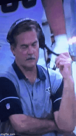 a man wearing headphones and a nfl shirt looks down
